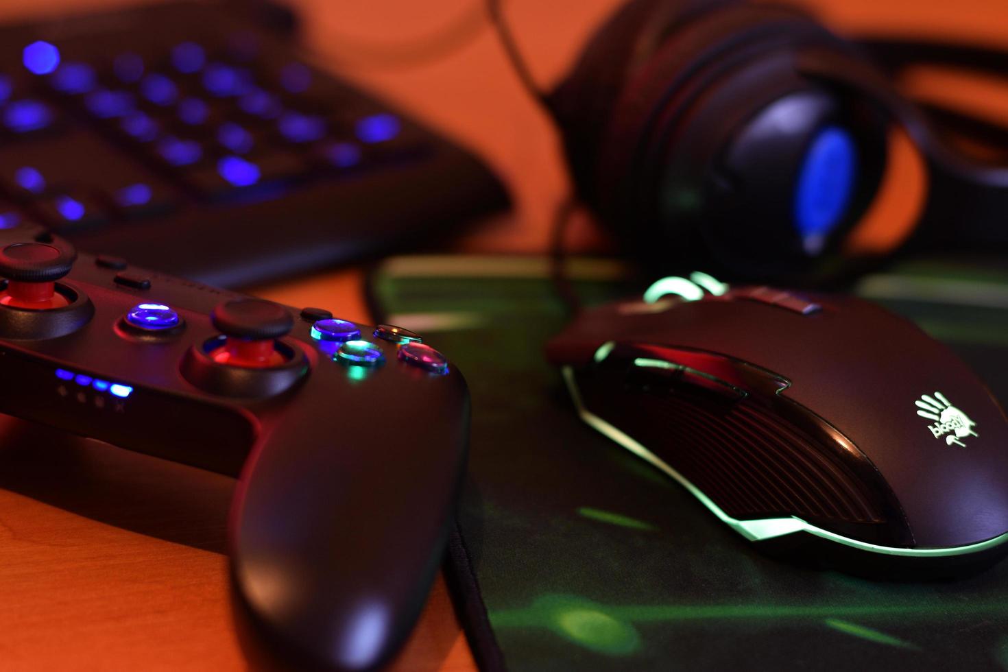 KHARKIV, UKRAINE - MAY 2, 2021 Gamesir g3s video game controller and Bloody p93 gaming mouse on office table with a4tech keyboard and headphones photo