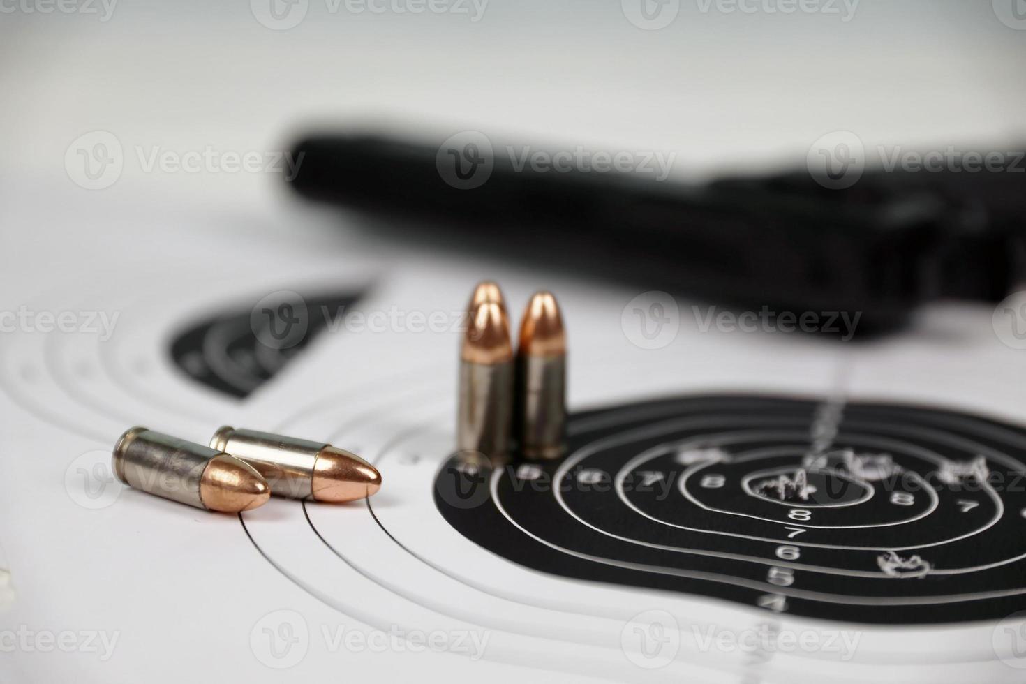 Gun and many bullets shooting targets on white table in shooting range polygon. Training for aiming and shooting photo