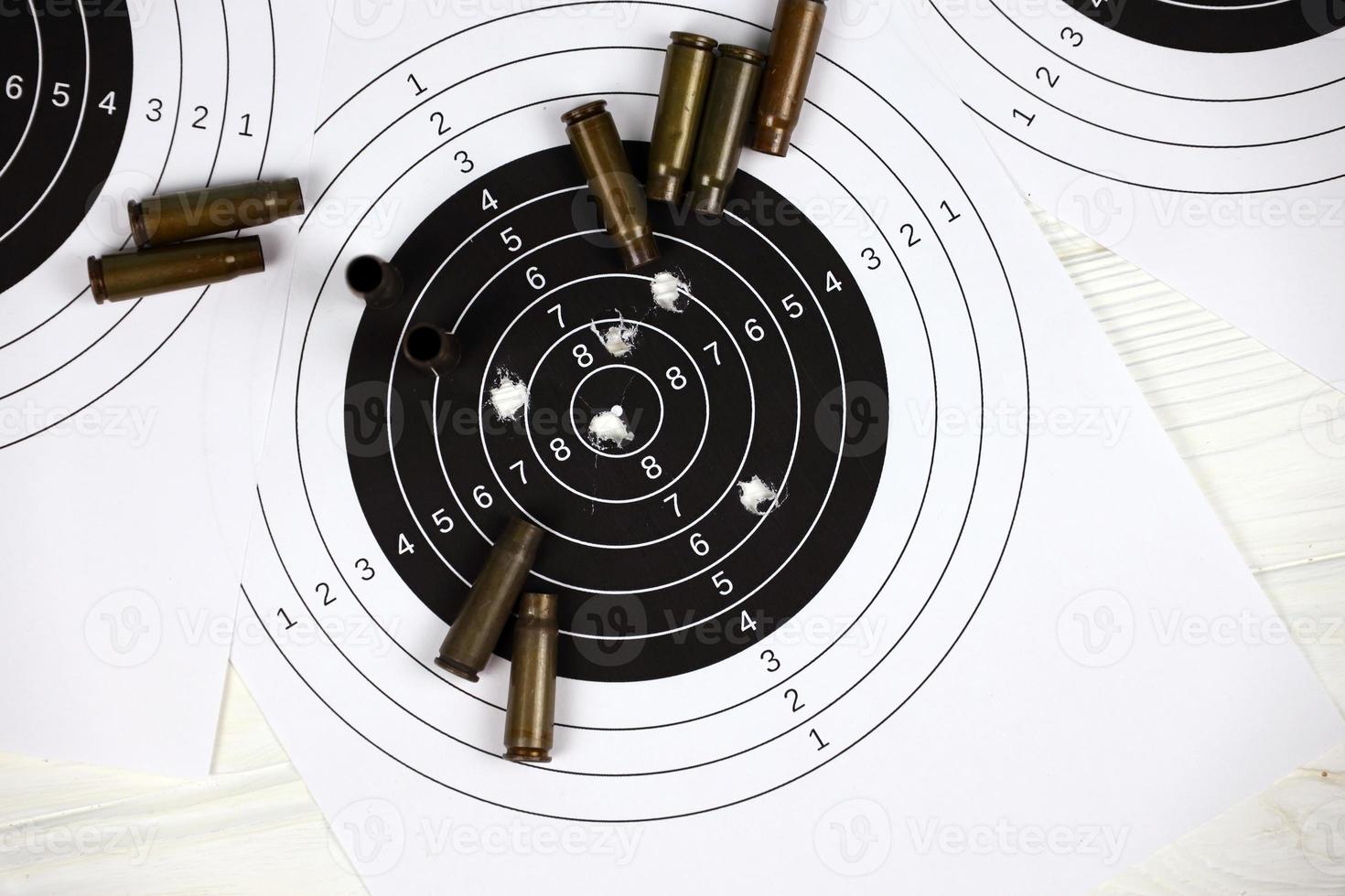 Many bullets on shooting targets on white table in shooting range polygon. Training for aiming and shooting photo