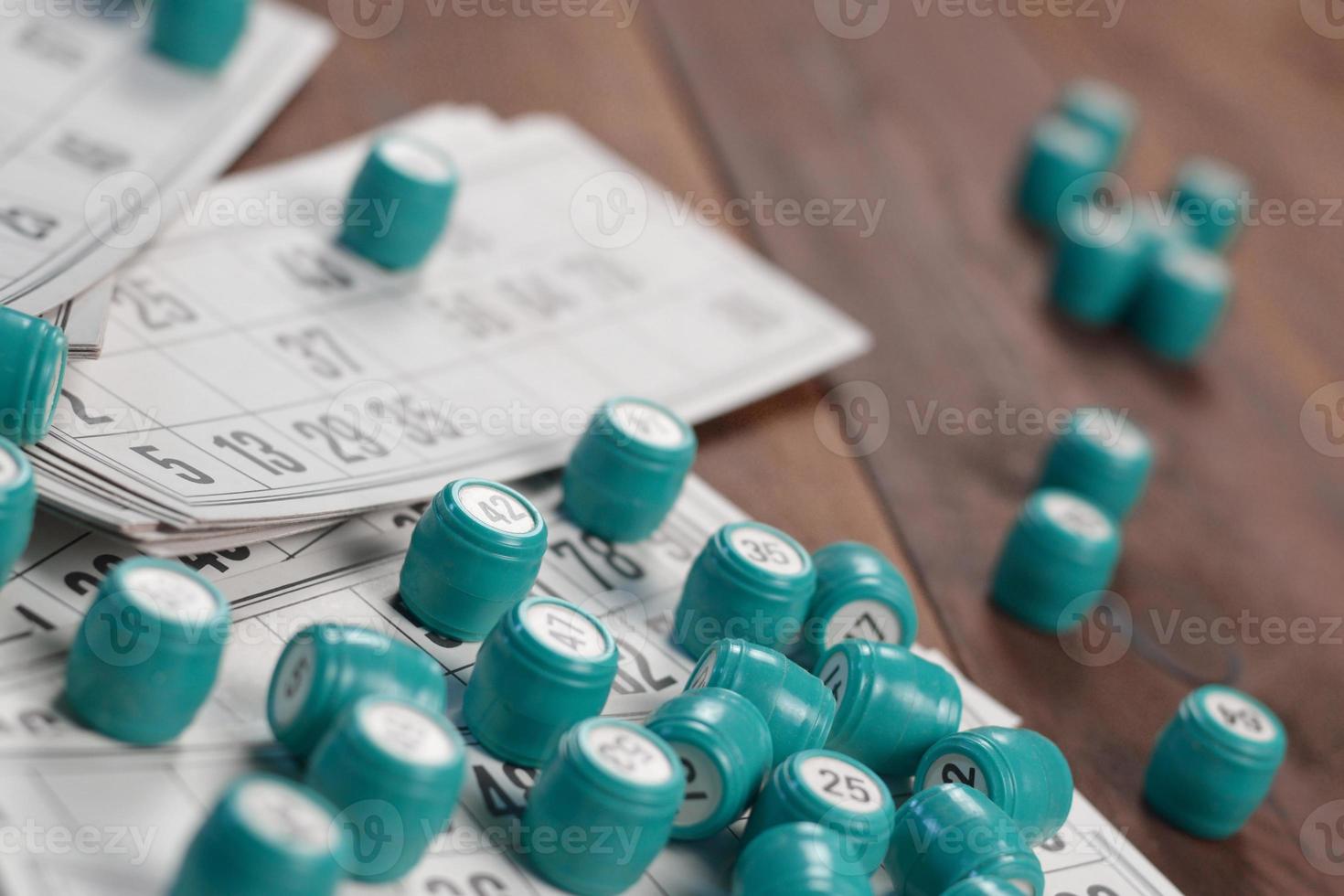 Many barrels with numbers and cards for lotto or russian bingo table game on wooden surface. Russian lotto has similar rules to classical worldwide bingo photo
