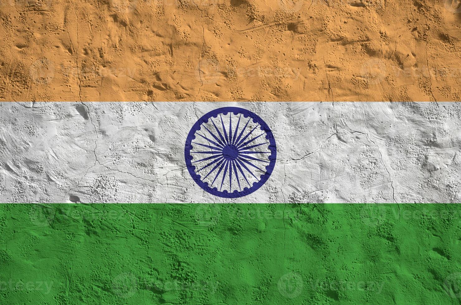 India flag depicted in bright paint colors on old relief plastering wall. Textured banner on rough background photo