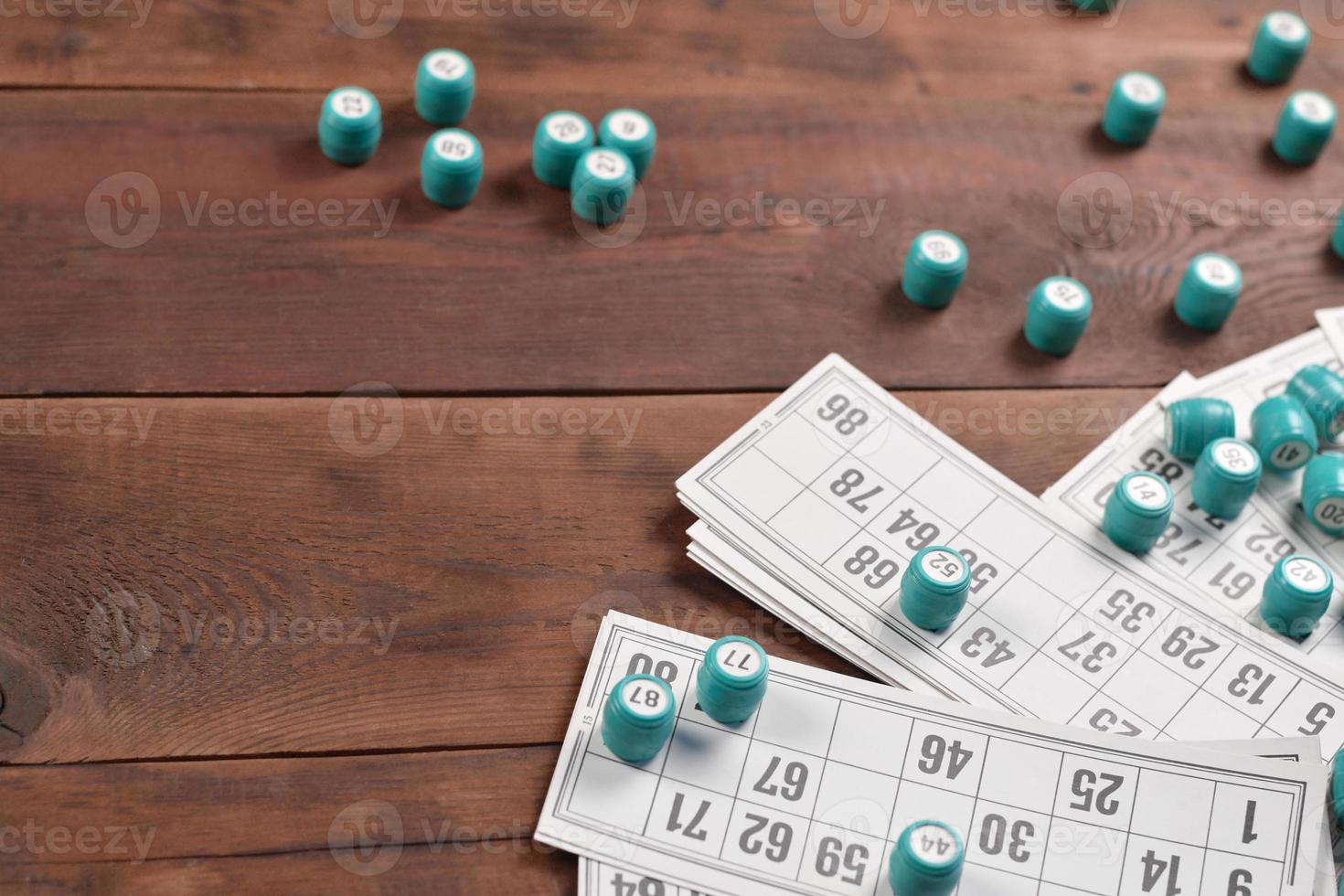 Many barrels with numbers and cards for lotto or russian bingo table game on wooden surface. Russian lotto has similar rules to classical worldwide bingo photo