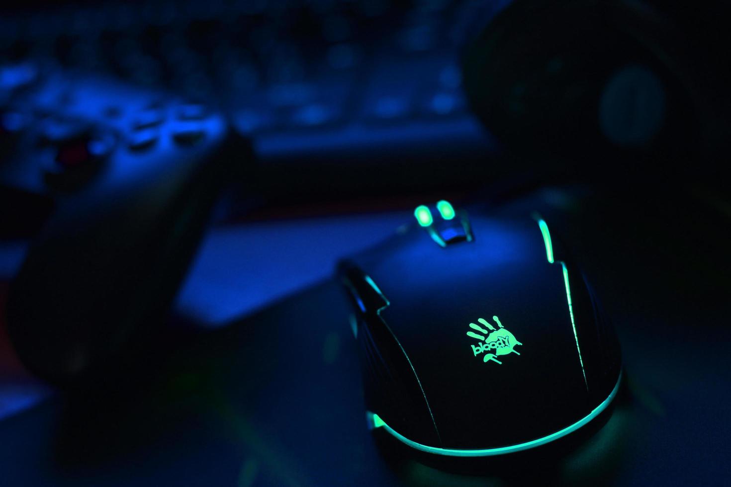 KHARKIV, UKRAINE - MAY 2, 2021 Gamesir g3s video game controller and Bloody p93 gaming mouse on office table with a4tech keyboard and headphones photo