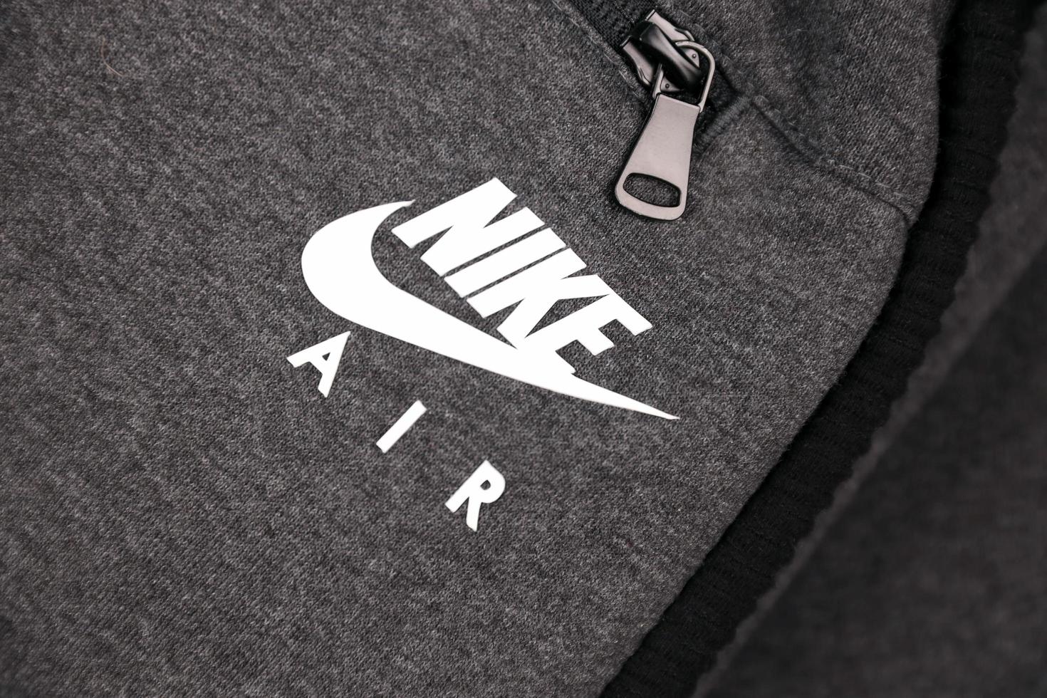 kharkov, ucrania - 20 de diciembre de 2020 logotipo de nike air en fragmento de ropa deportiva gris. Nike es una corporación multinacional estadounidense dedicada a la fabricación y comercialización mundial de ropa y calzado. foto