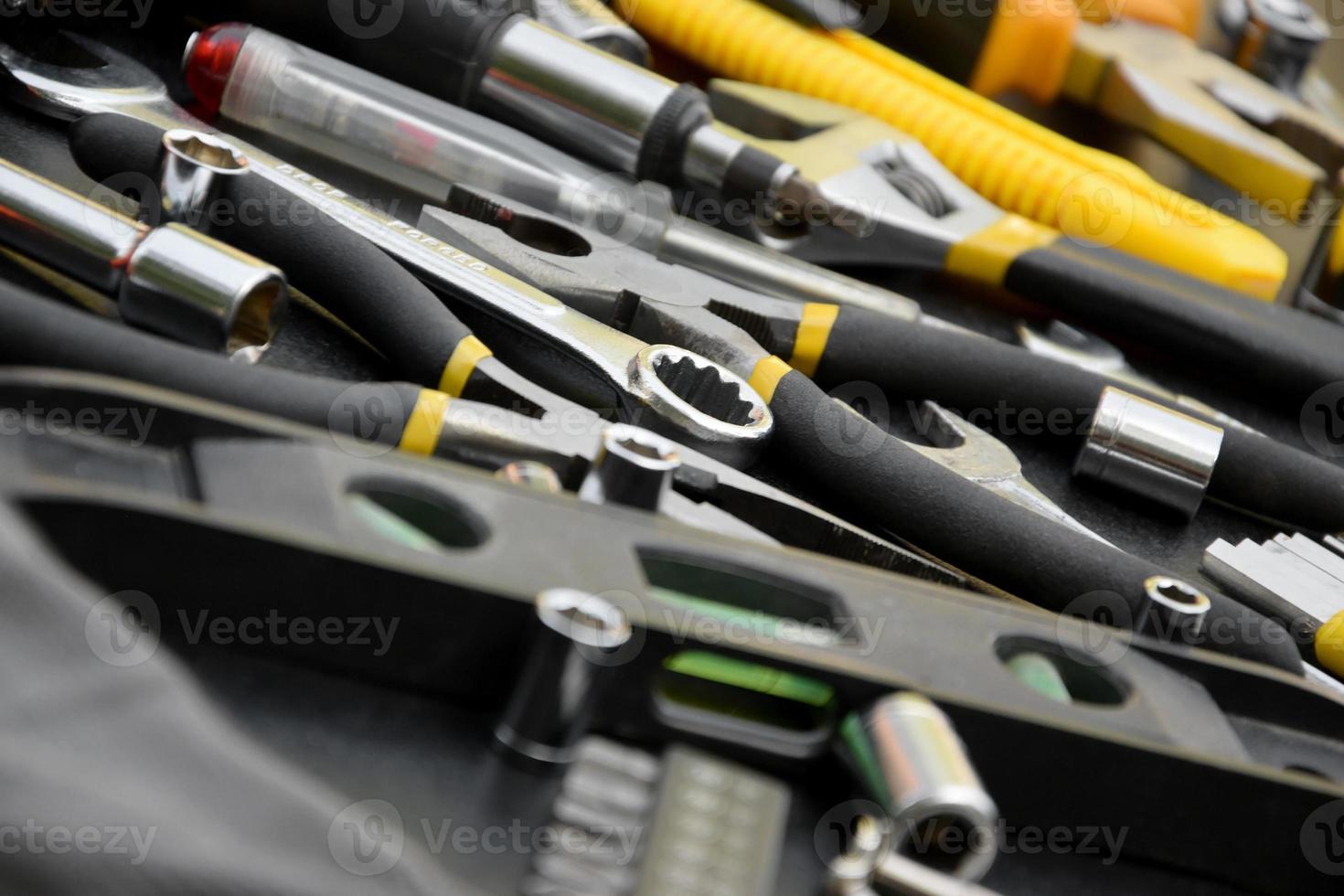 Handyman tool kit on black wooden table. Many wrenches and screwdrivers, pilers and other tools for any types of repair or construction works. Repairman tools photo