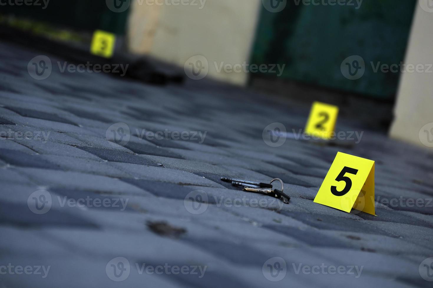 Evidence with yellow CSI marker for evidence numbering on the residental backyard in evening. Crime scene investigation concept photo