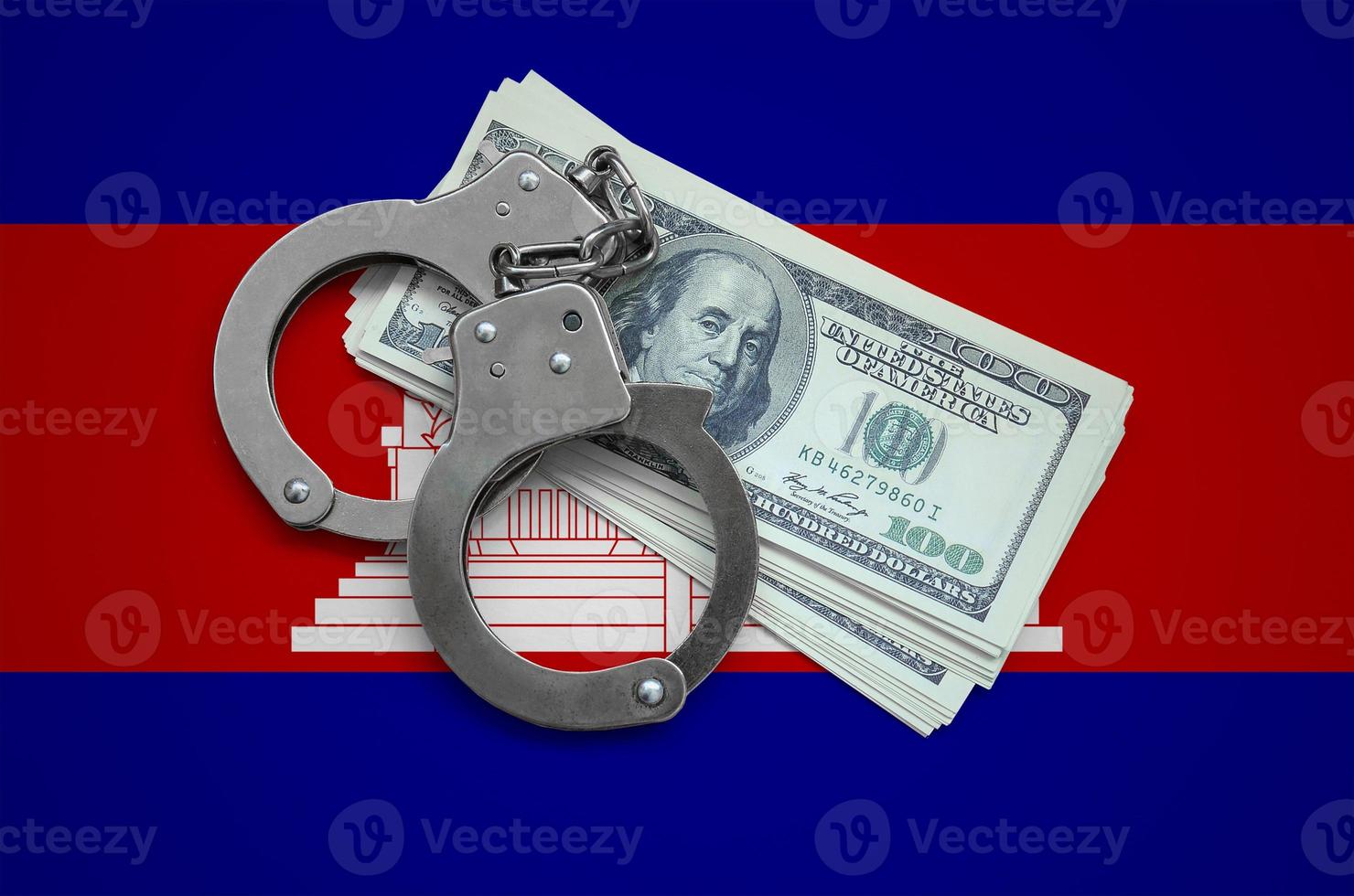 Cambodia flag  with handcuffs and a bundle of dollars. Currency corruption in the country. Financial crimes photo