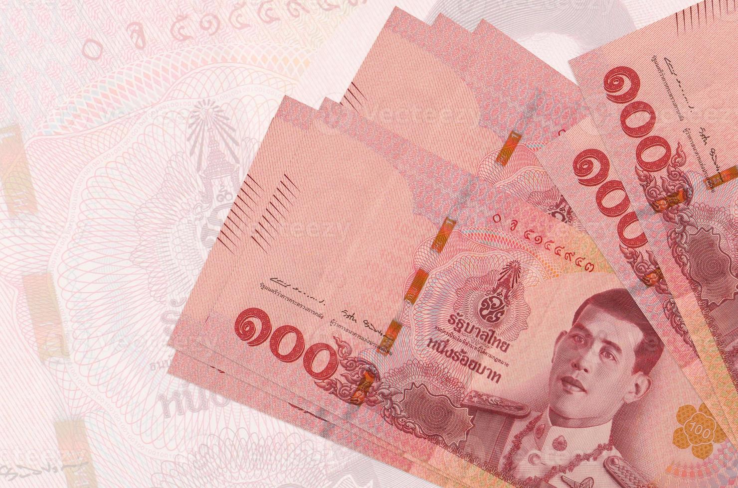 100 Thai baht bills lies in stack on background of big semi-transparent banknote. Abstract presentation of national currency photo