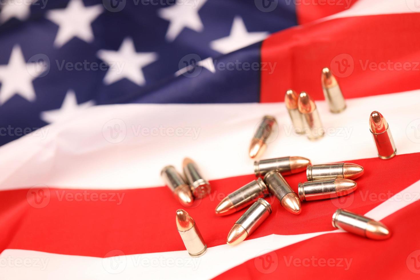 Many yellow 9mm bullets and cartridges on United States flag. Concept of gun trafficking on USA territory or special ops photo