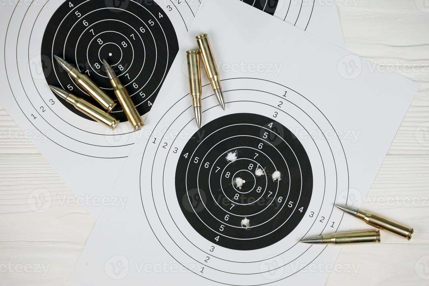 Many bullets on shooting targets on white table in shooting range polygon. Training for aiming and shooting photo
