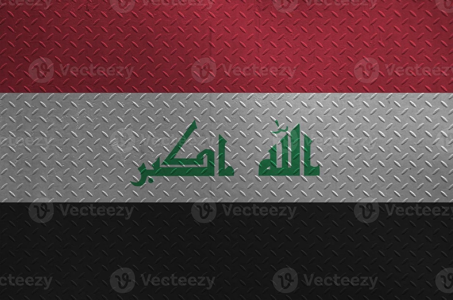 Iraq flag depicted in paint colors on old brushed metal plate or wall closeup. Textured banner on rough background photo