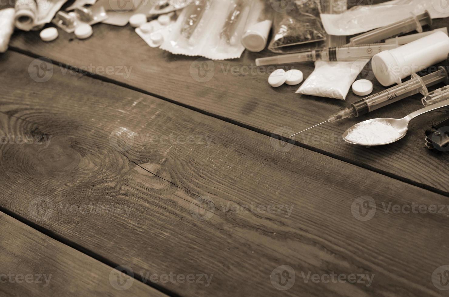 A lot of narcotic substances and devices for the preparation of drugs lie on an old wooden table photo