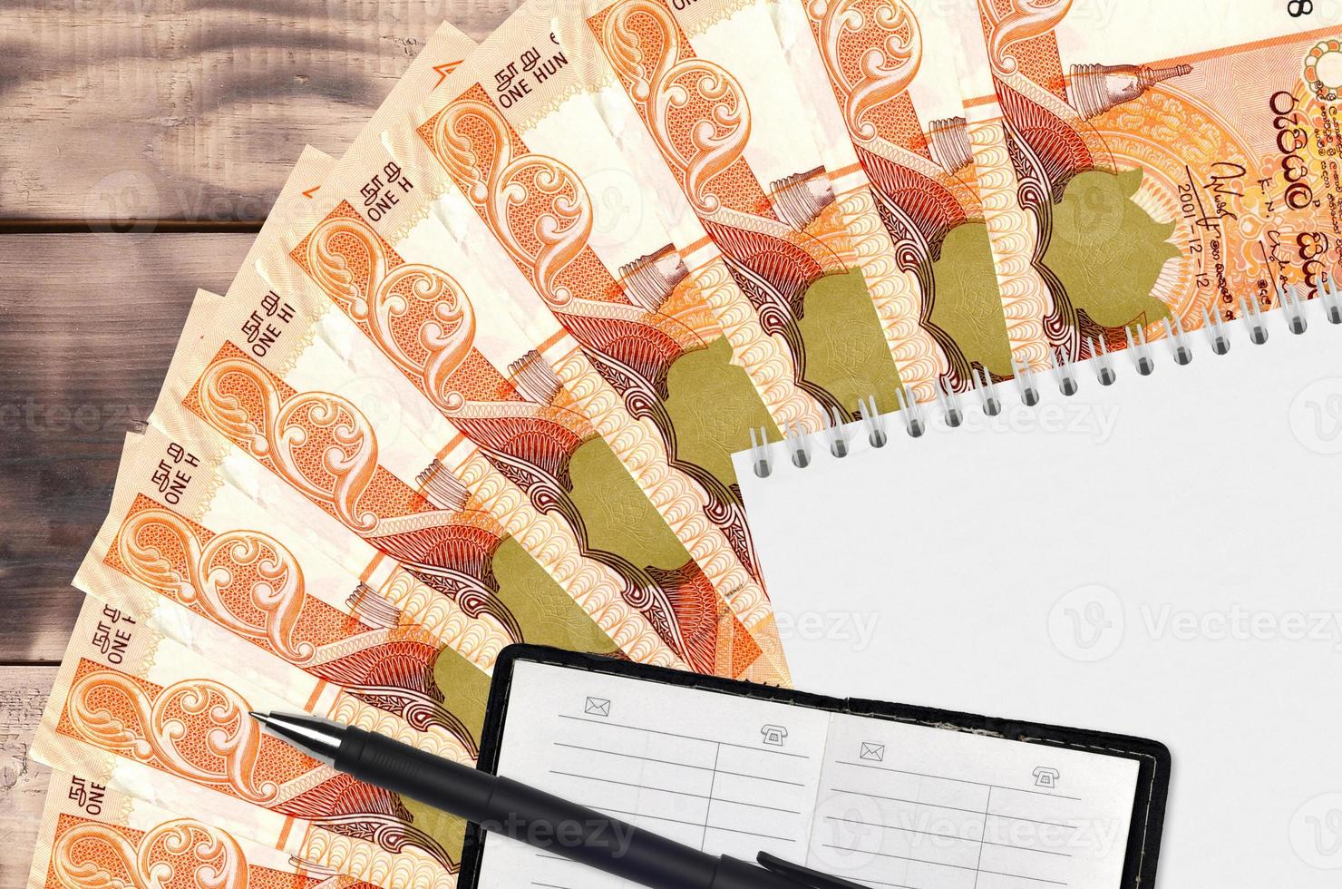 100 Sri Lankan rupees bills fan and notepad with contact book and black