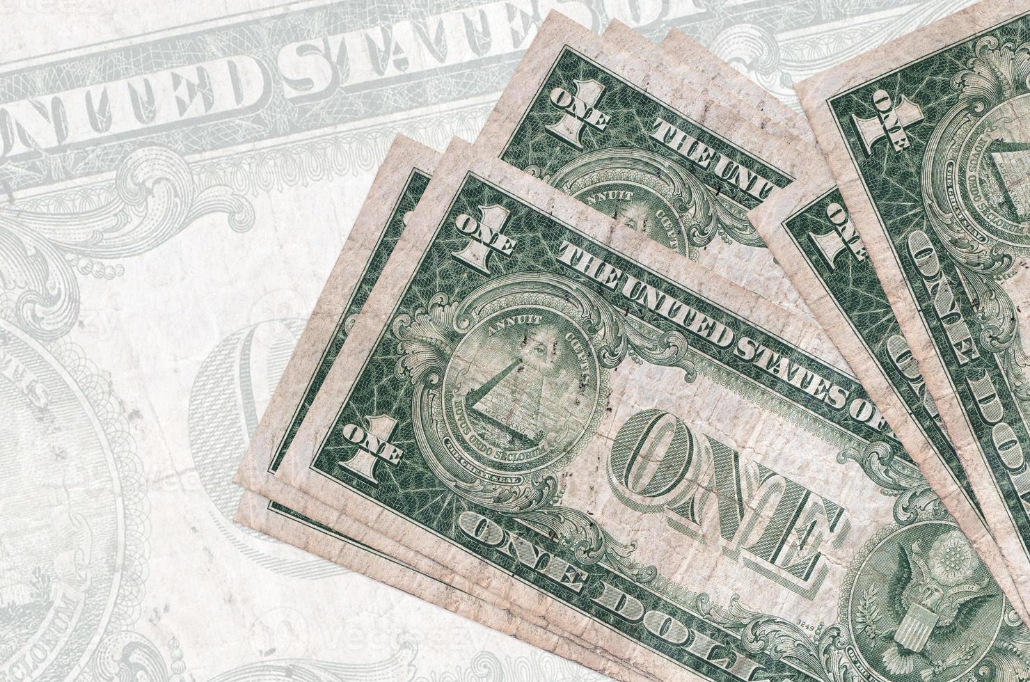 1 US dollar bills lies in stack on background of big semi-transparent banknote. Abstract presentation of national currency photo