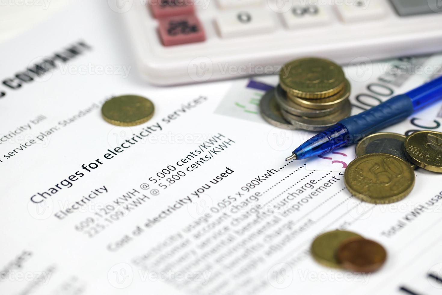 Calculator and Euro bills with pen on european electricity bill. Concept of saving money by using energy savings led light bulbs and electric bill payment photo