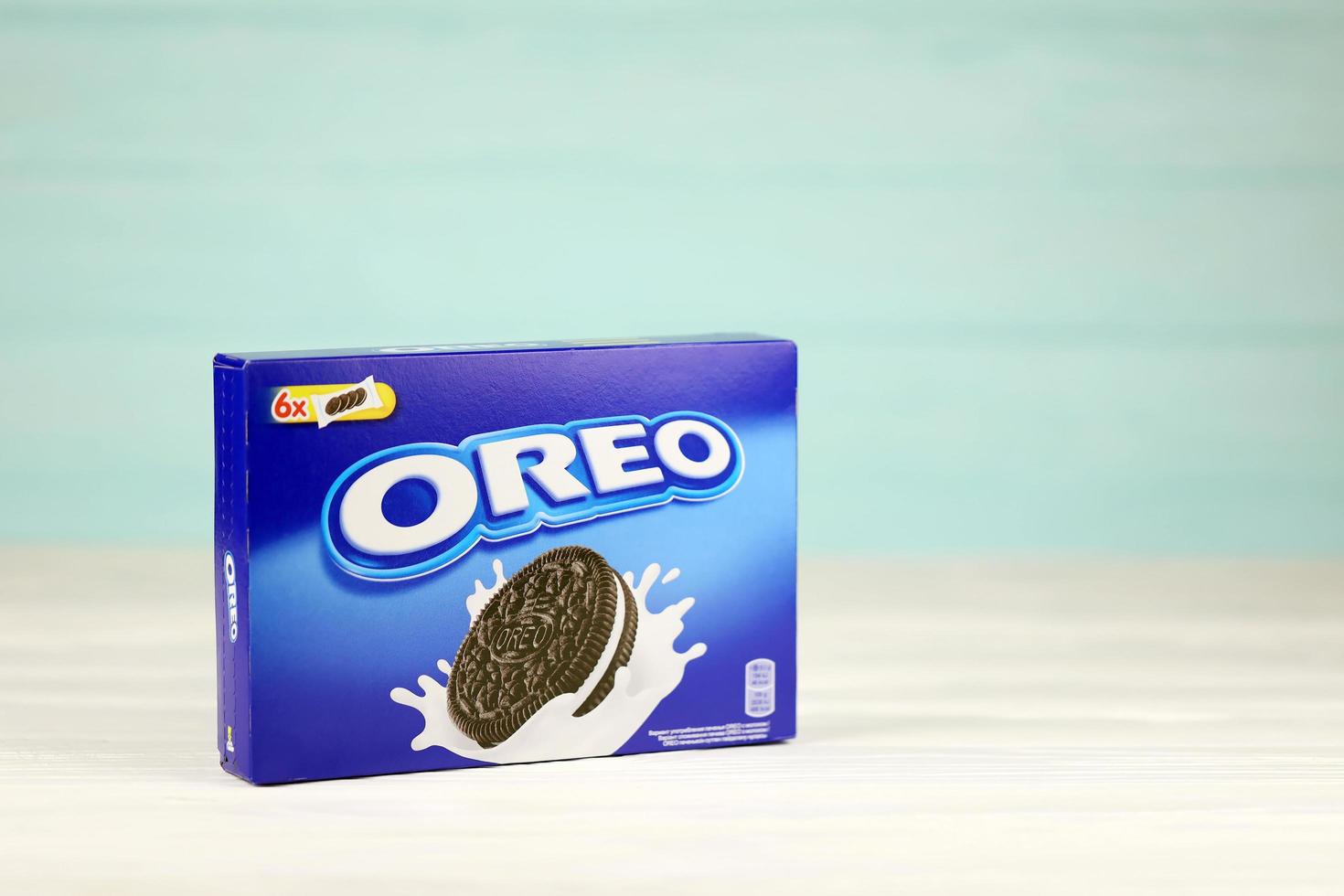 KHARKIV, UKRAINE - MAY 02, 2021 Oreo blue product box on white and light blue wooden background. Oreo is a sandwich cookie with a sweet cream is the best selling cookie in the US photo