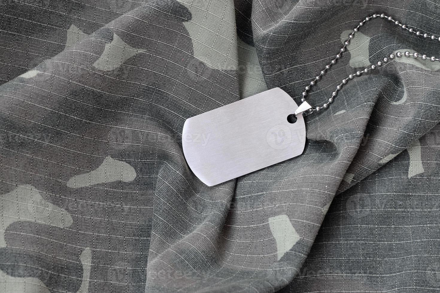 Silvery military beads with dog tag on camouflage fatigue uniform photo