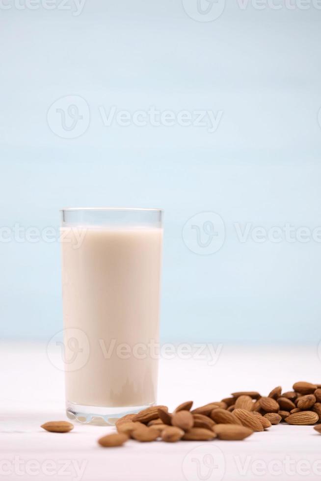 Glass of almond milk with almond nuts on white wooden table. Dairy alternative milk for detox, healthy eating and diets photo