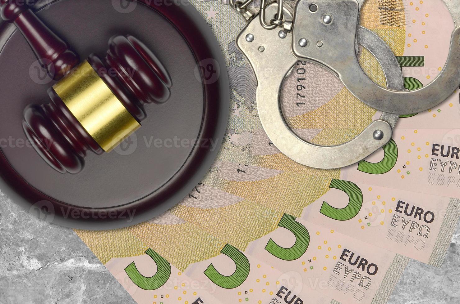 5 euro bills and judge hammer with police handcuffs on court desk. Concept of judicial trial or bribery. Tax avoidance photo