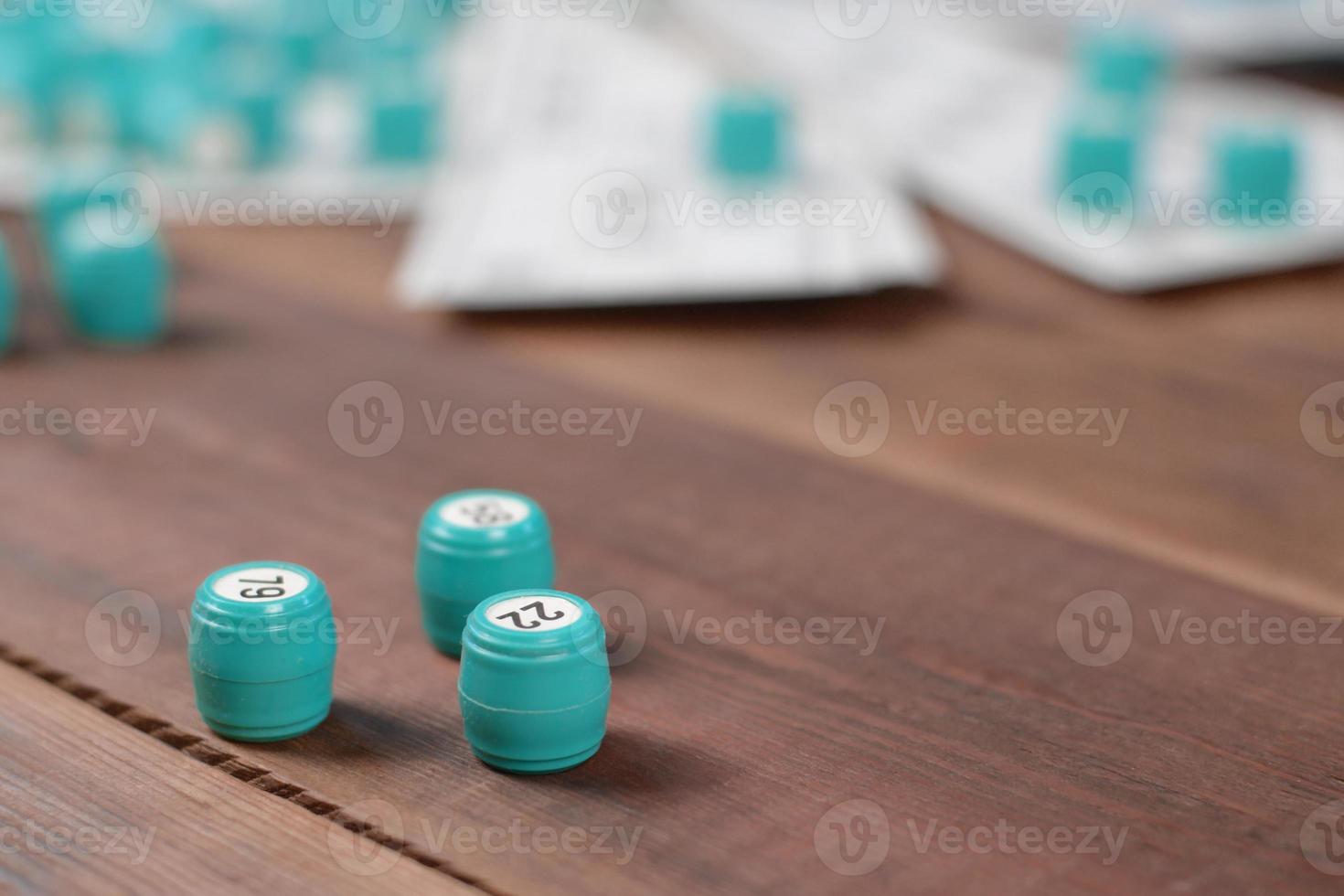 Many barrels with numbers and cards for lotto or russian bingo table game on wooden surface. Russian lotto has similar rules to classical worldwide bingo photo