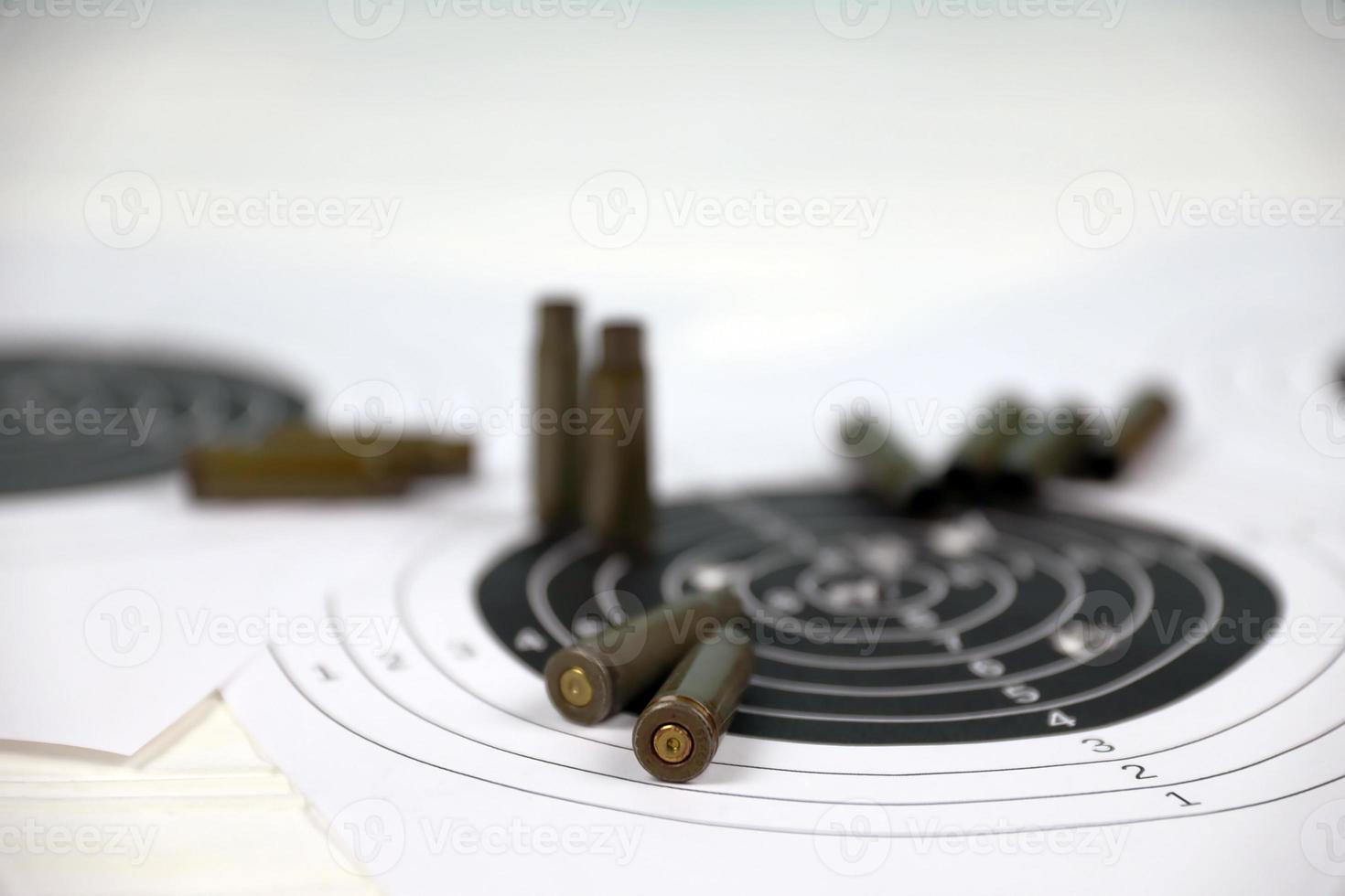 Many bullets on shooting targets on white table in shooting range polygon. Training for aiming and shooting photo