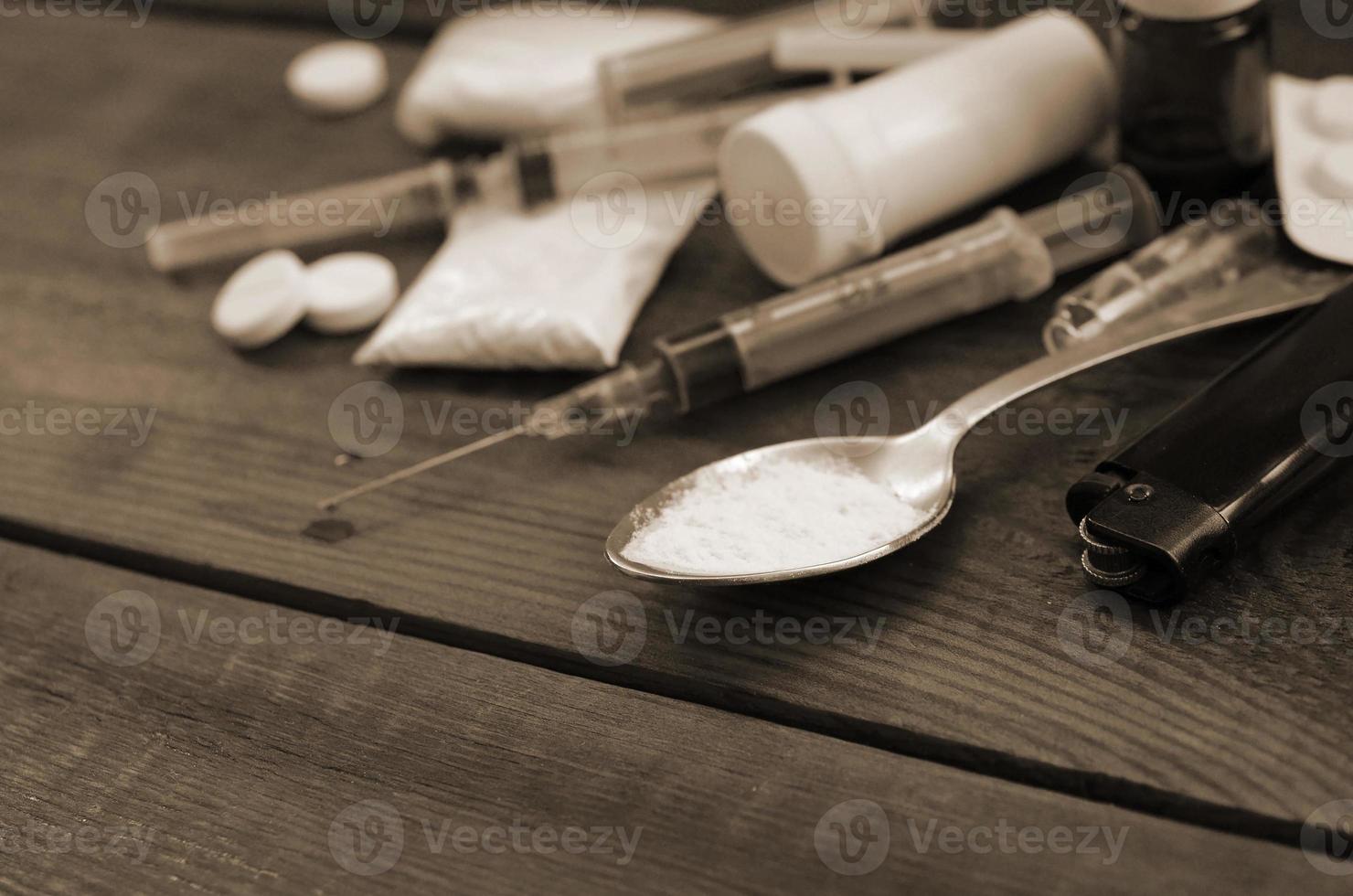 A lot of narcotic substances and devices for the preparation of drugs lie on an old wooden table photo