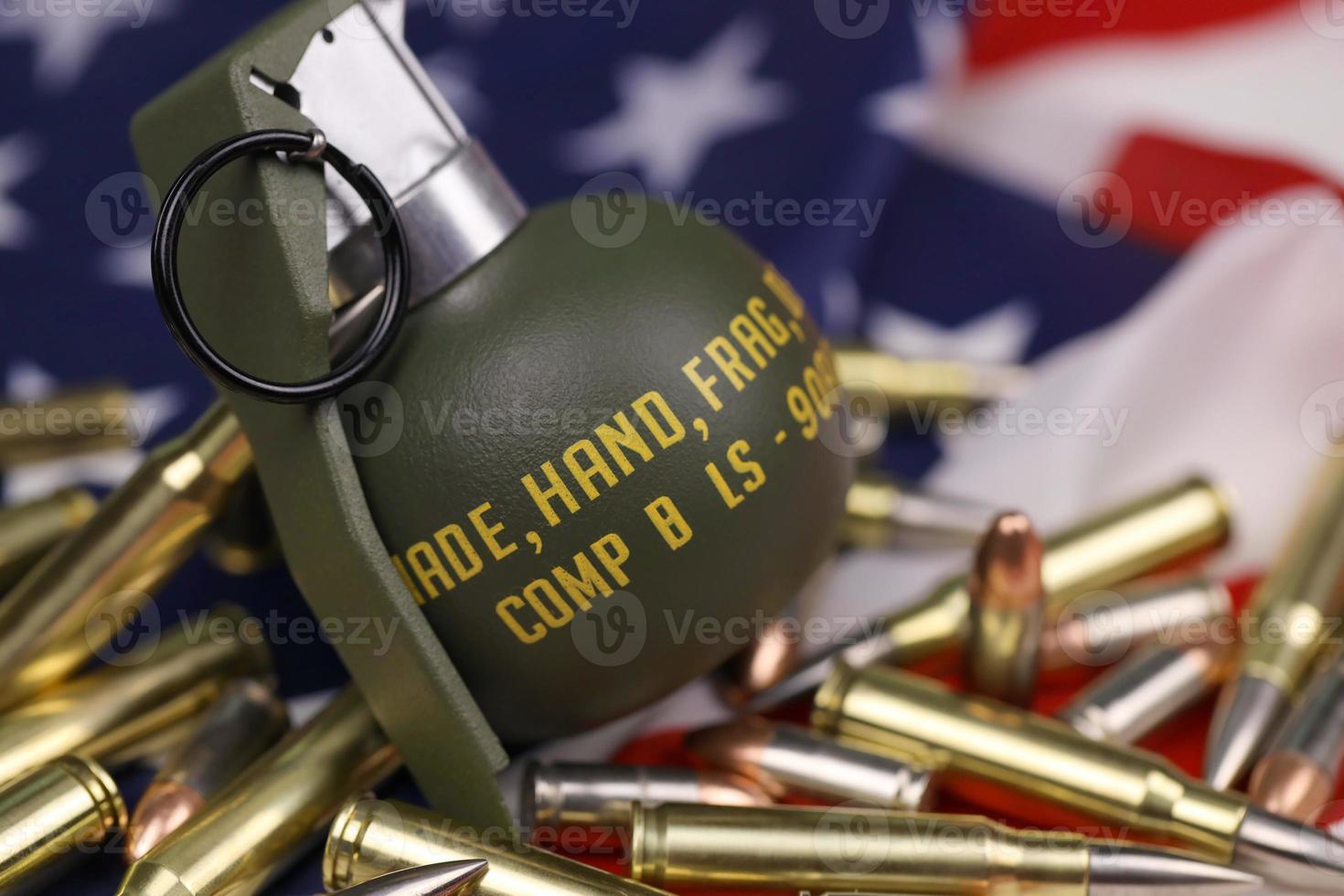 M67 frag grenade and many yellow bullets and cartridges on United States flag. Concept of gun trafficking on USA territory or spec ops photo