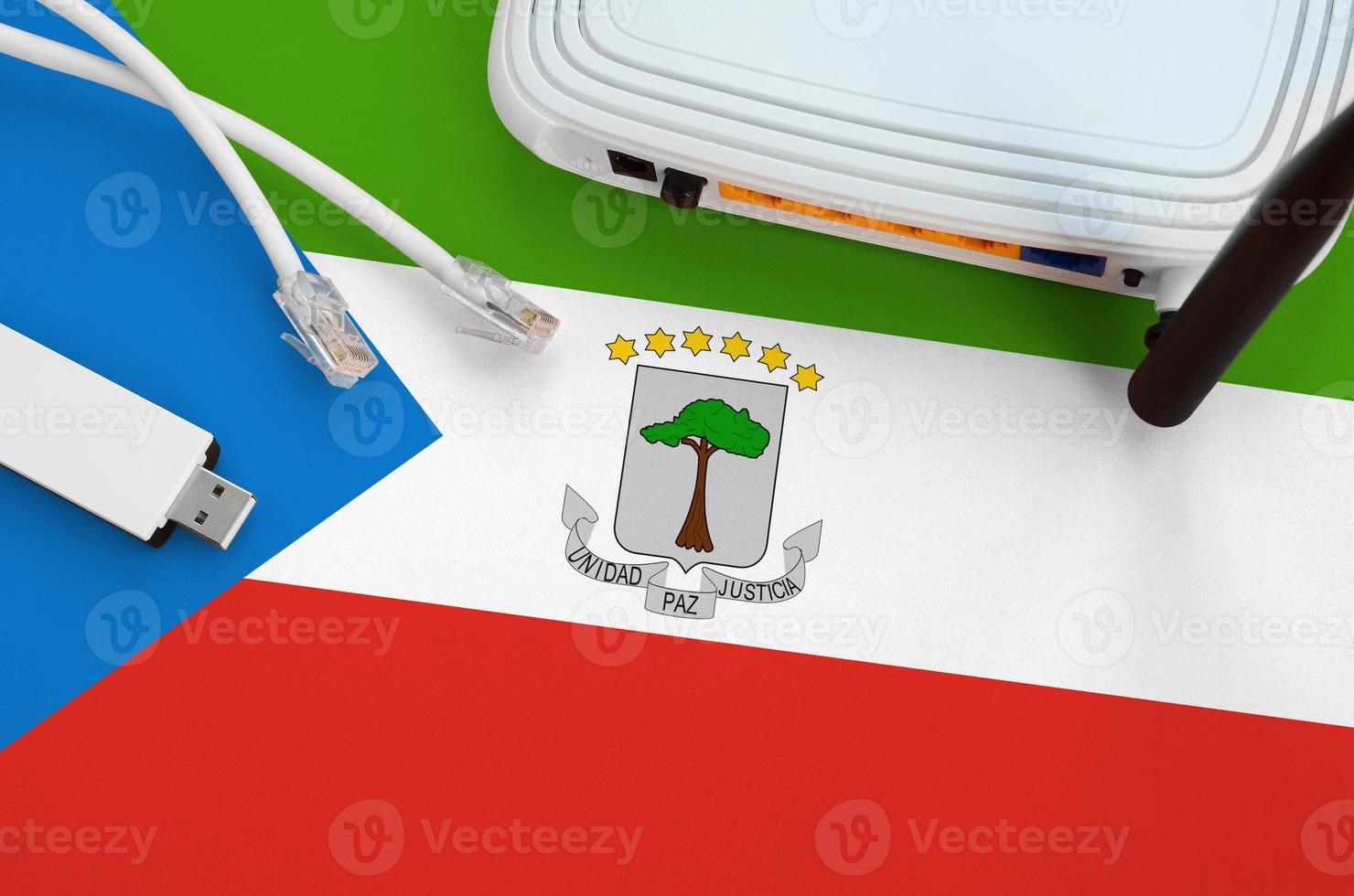Equatorial Guinea flag depicted on table with internet rj45 cable, wireless usb wifi adapter and router. Internet connection concept photo