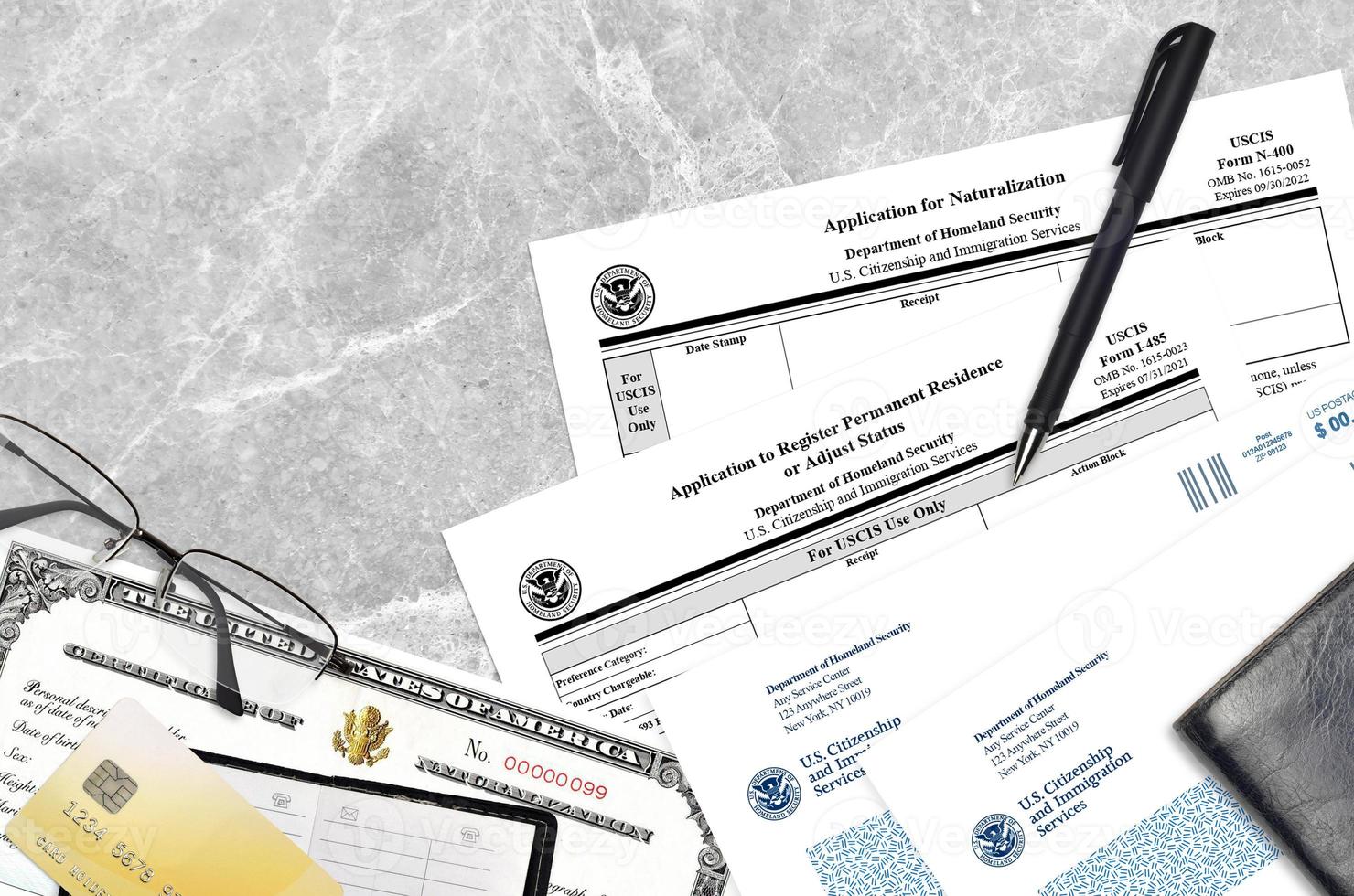 USCIS form I-485 Application to register permanent residence or adjust status and N-400 Application for naturalization with Certificate of naturalization lies on office table photo