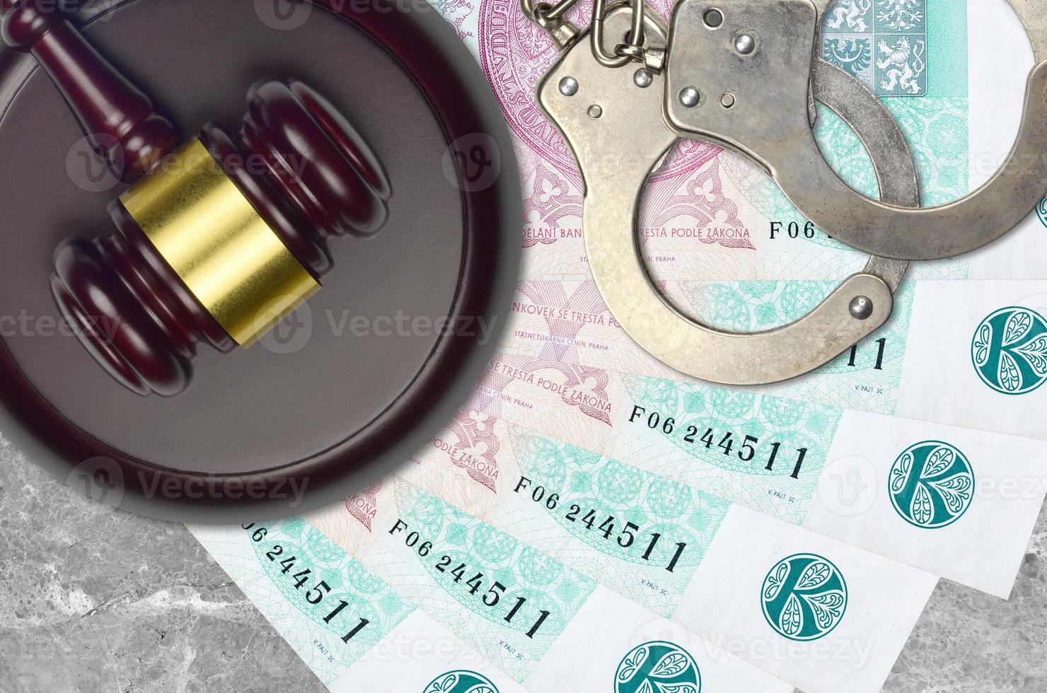100 Czech korun bills and judge hammer with police handcuffs on court desk. Concept of judicial trial or bribery. Tax avoidance photo