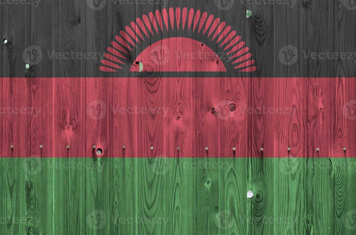 Malawi flag depicted in bright paint colors on old wooden wall. Textured banner on rough background photo
