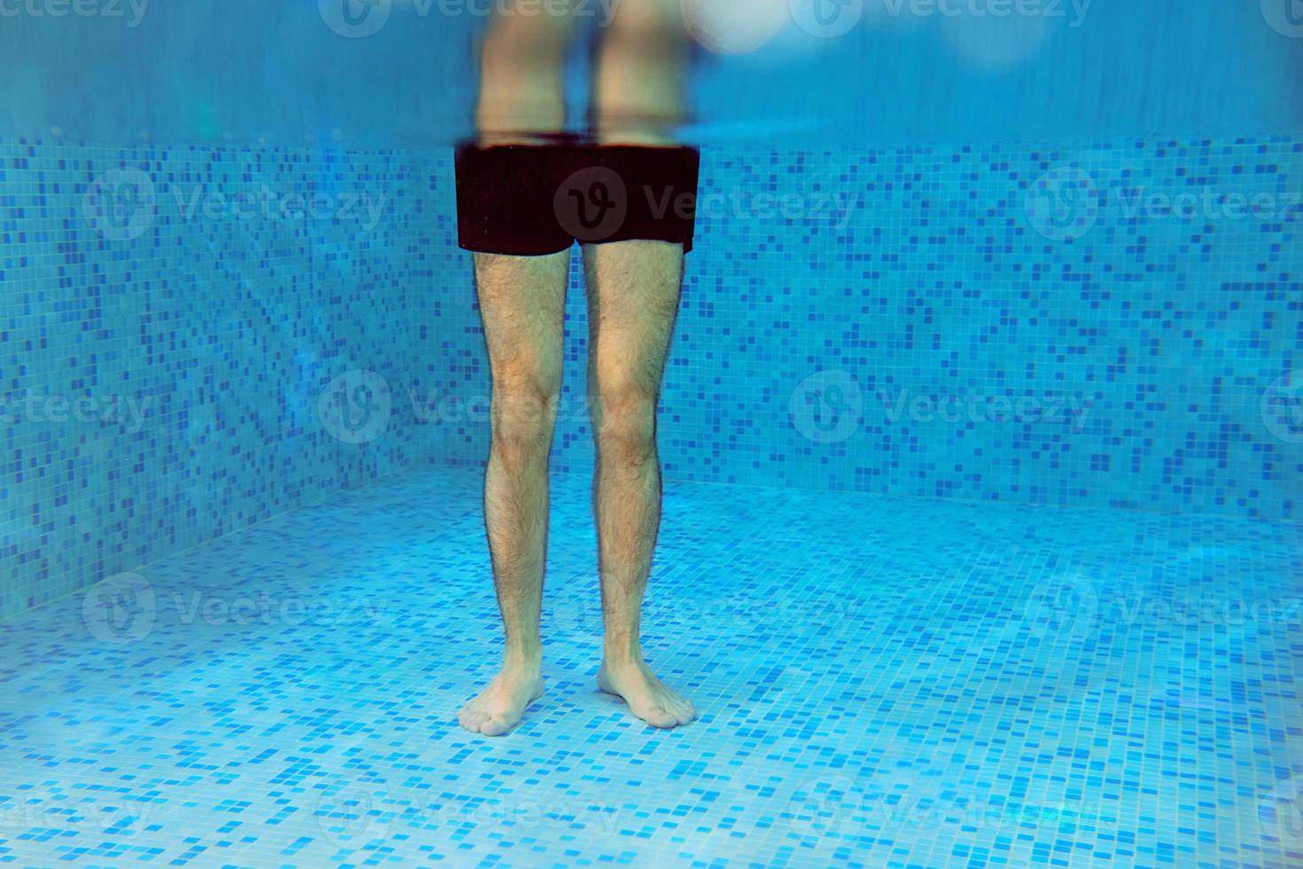 Men legs underwater in the swimming pool. Travel, recreation, sport, laser epilation concept photo