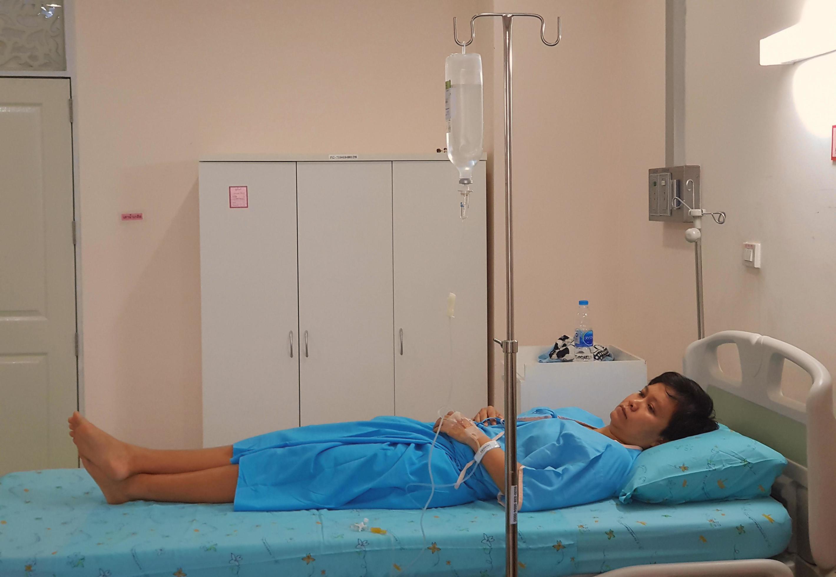 female patient lying on patient's bed in patient's room at hospital