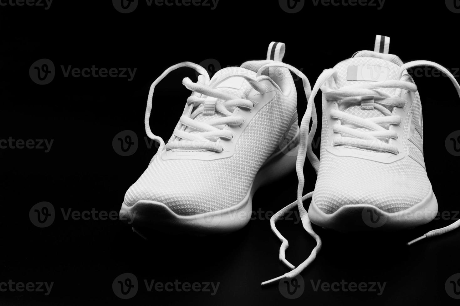 a pair of brand new woman white sneakers on black photo