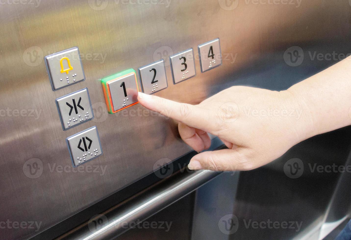 mano de mujer presionando el botón del ascensor foto