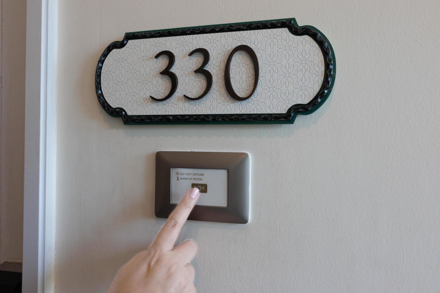 finger pressing on electronic doorbell photo