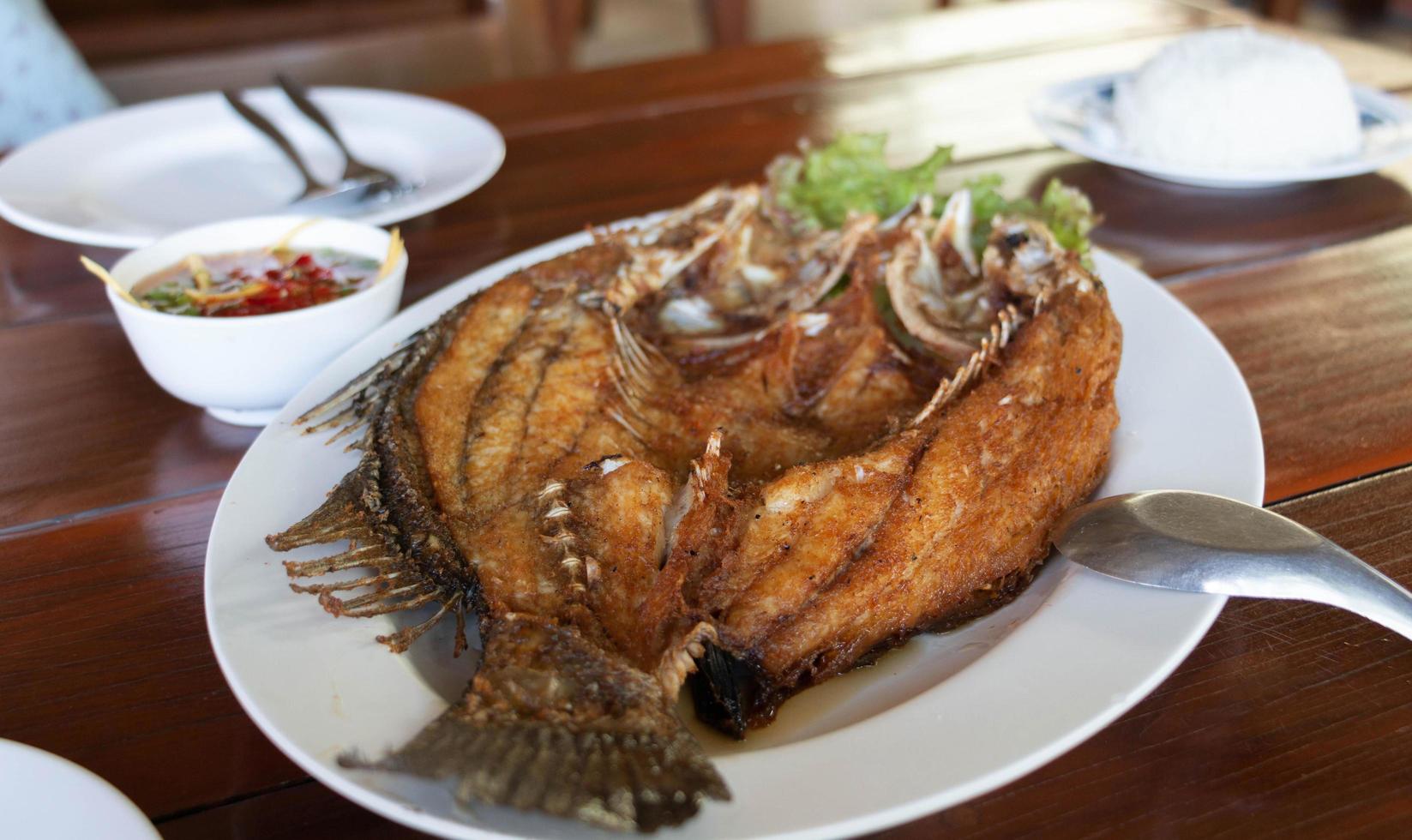 lubina frita con salsa de pescado foto