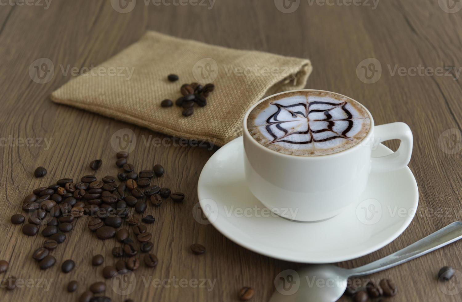 Coffee in a mug  and beans and sack bag on a wood grain background photo