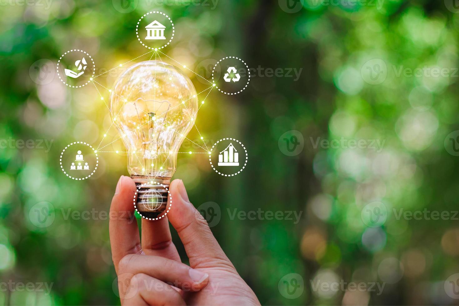 Hand holding light bulb against nature for environmental, social, and governance in sustainable and ethical business on the Network connection, ESG icon concept. photo