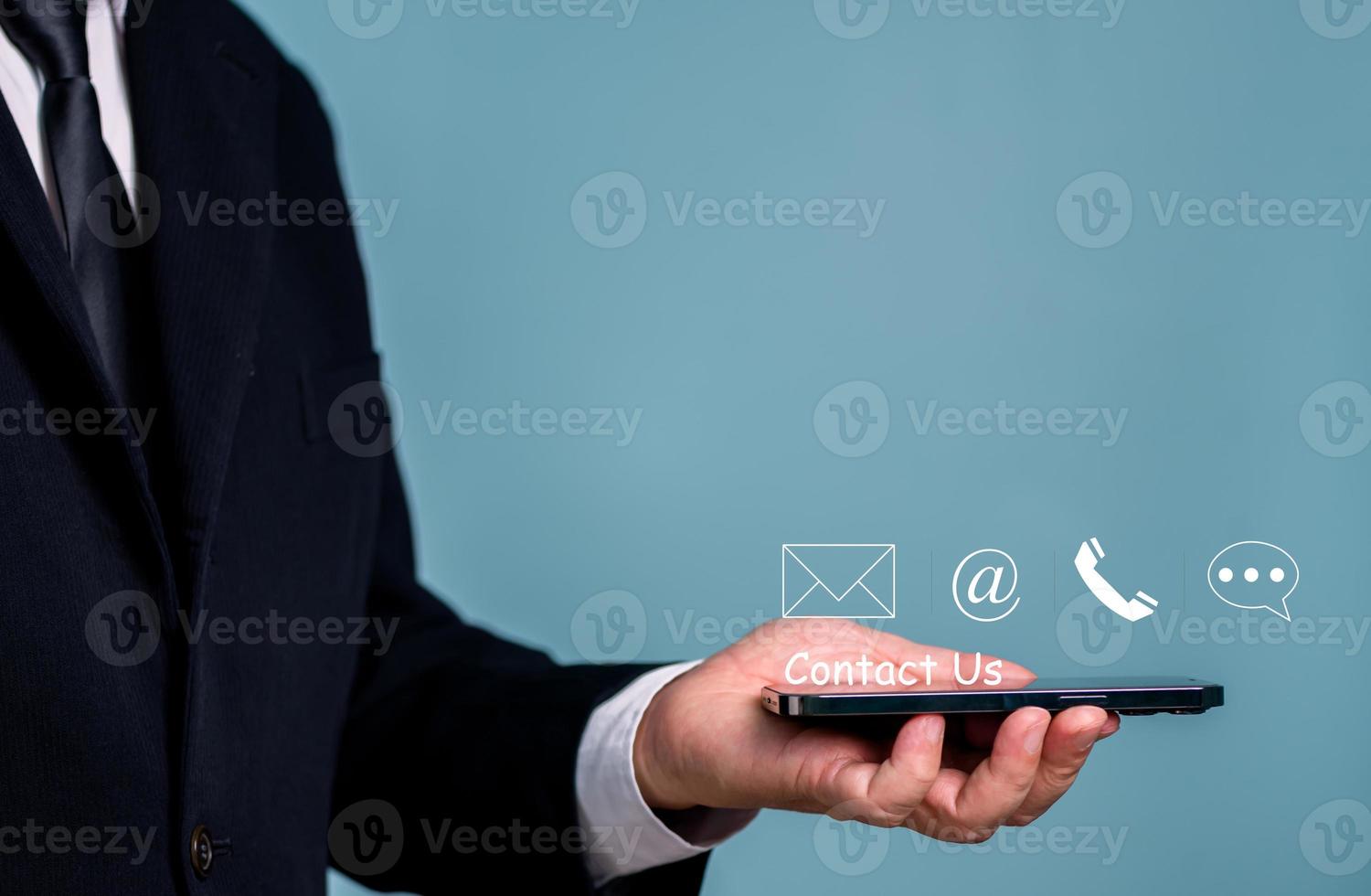 Contact Us, Hand of Businessman holding mobile phone with mail, phone, email, message icon. customer support concept, copy space. photo