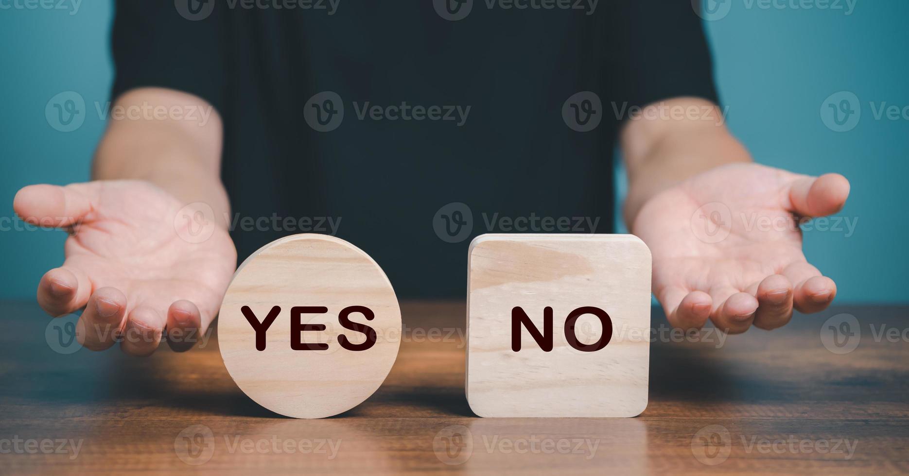Yes or no choice symbol. Hand making a question gesture to choice between two cubes with Yes and No icon on the desk. Business and yes or no choice concept. photo