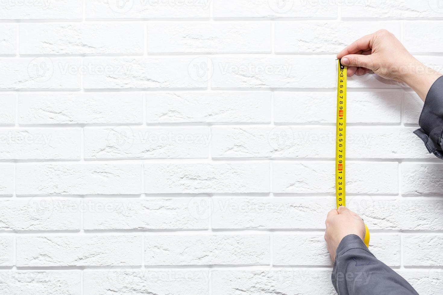 a man with a centimeter on a white background. photo