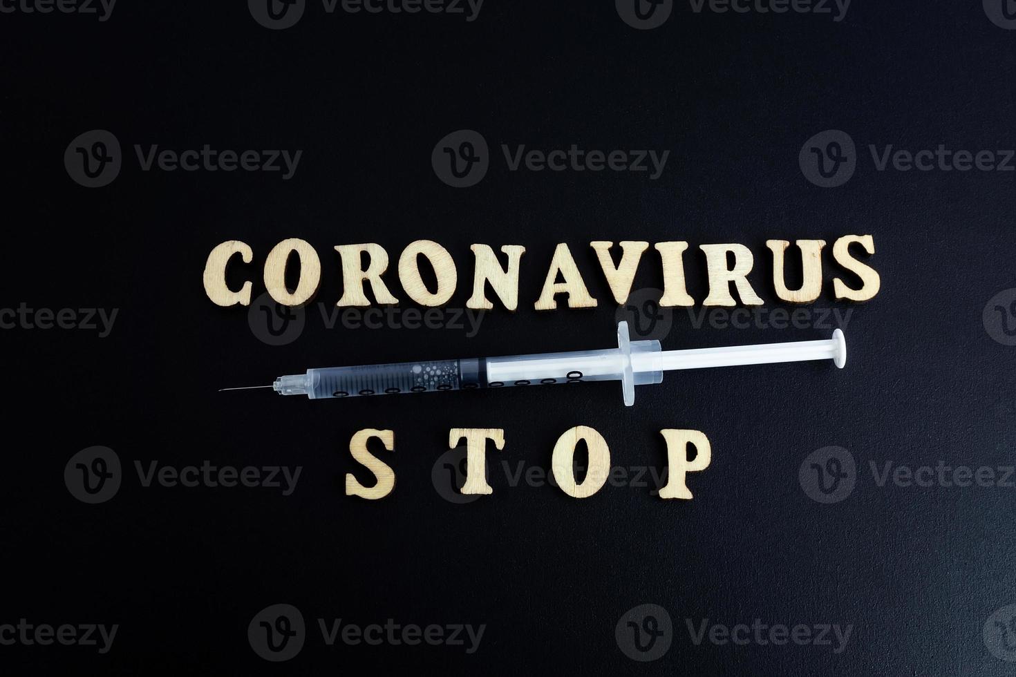 one syringe with a dose of medicine or vaccine on a black background with a space for the text vaccinations against the influenza coronavirus photo
