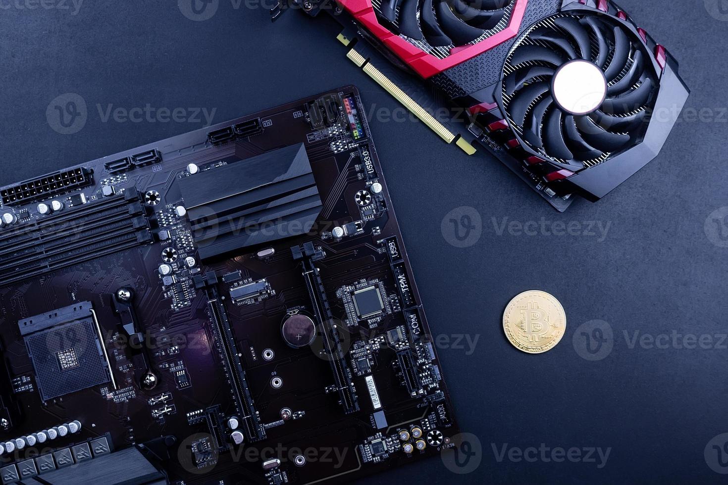 cryptocurrency mining concept with golden bitcoin coins next to a computer performant video card black background photo