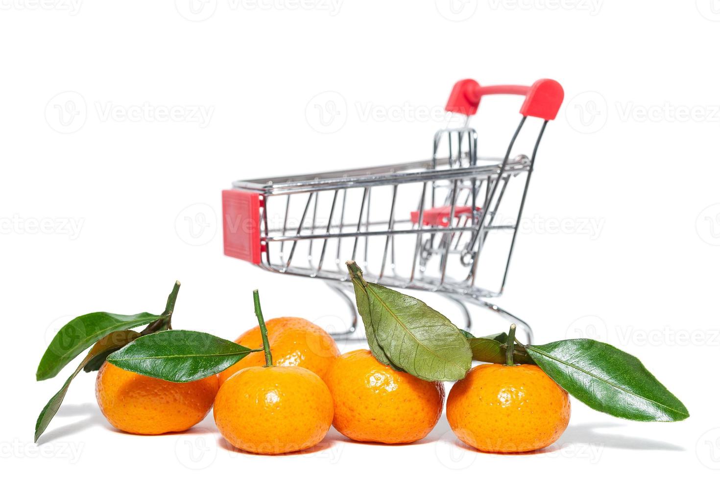 fresh mangerines and a shopping cart on a white isolated background photo