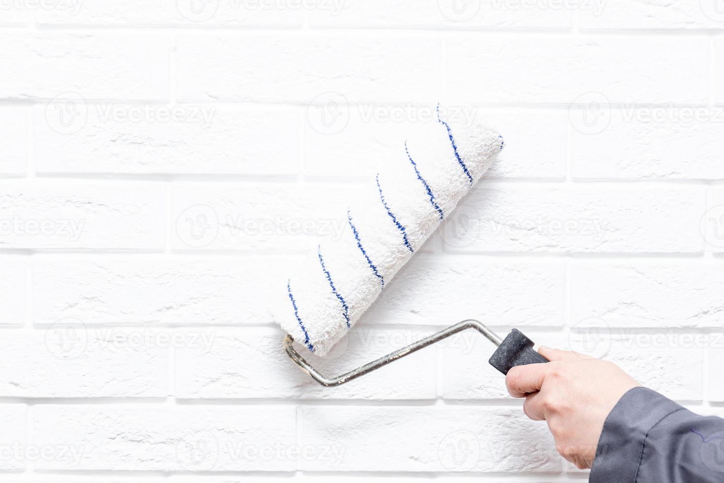 worker paints the white wall white cushion photo
