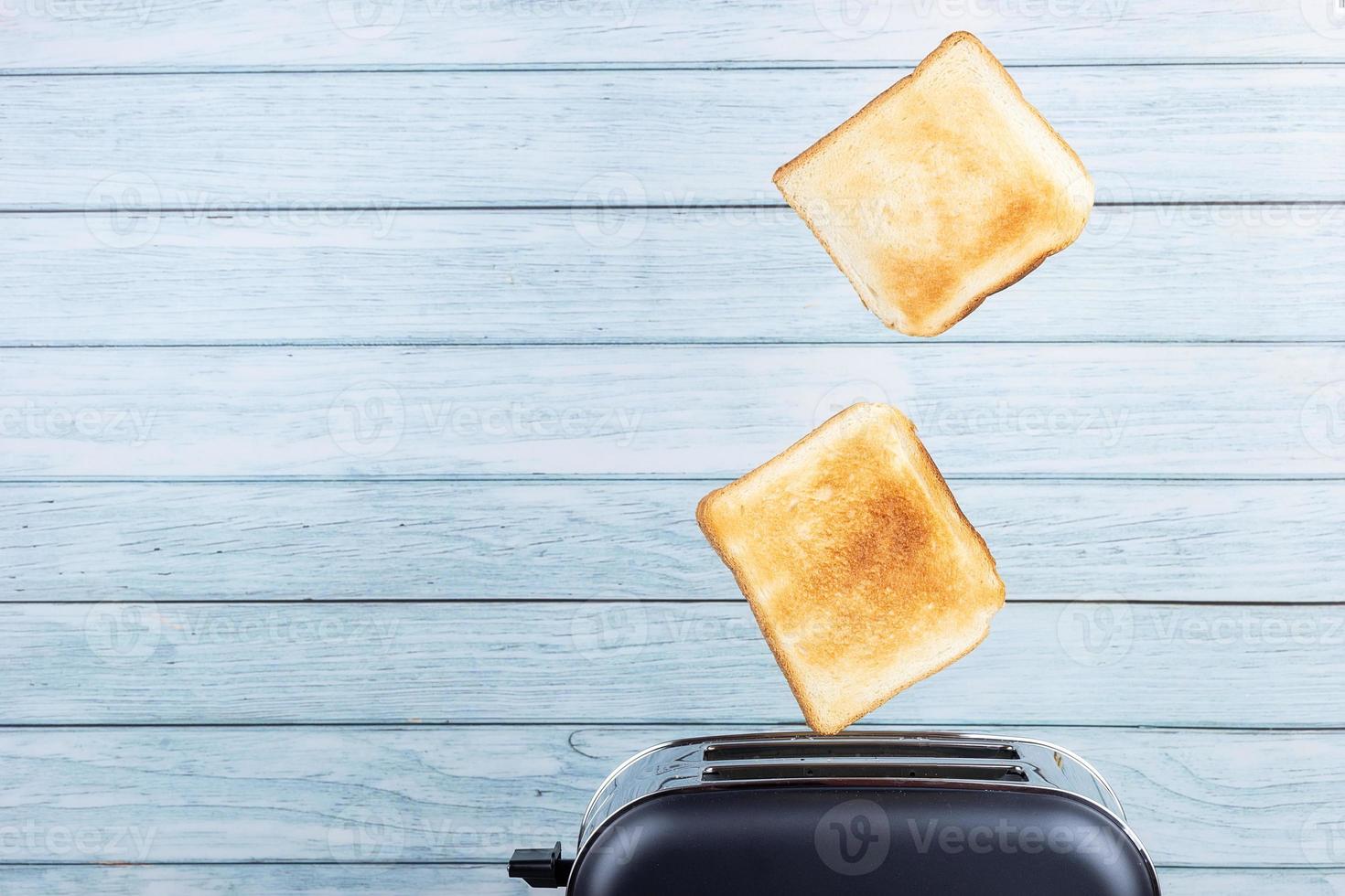bread toaster jumping on wooden background photo
