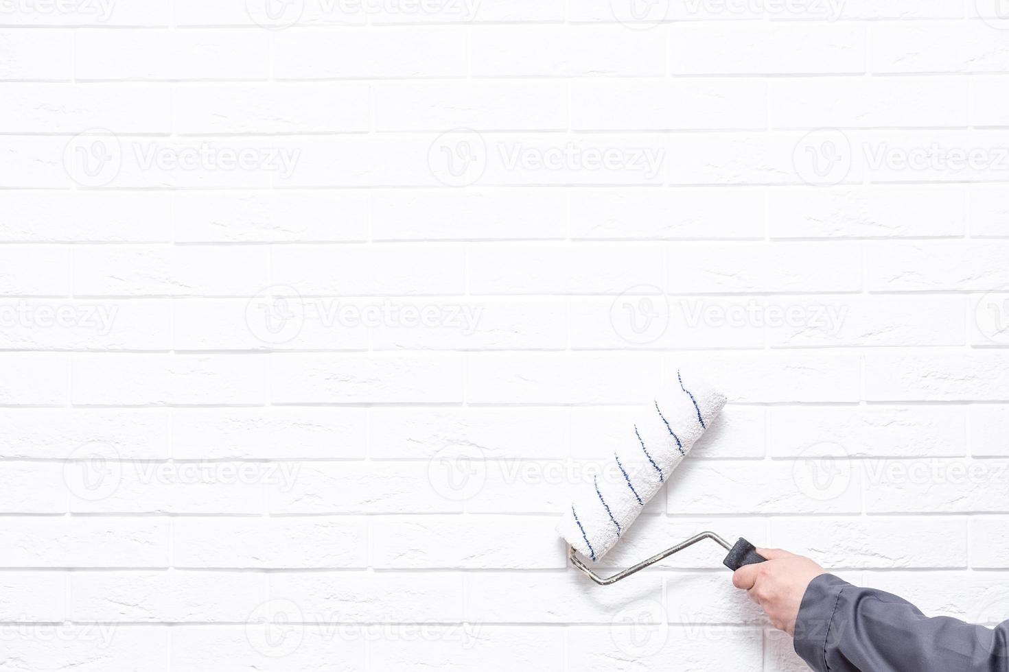 worker paints the white wall white cushion photo