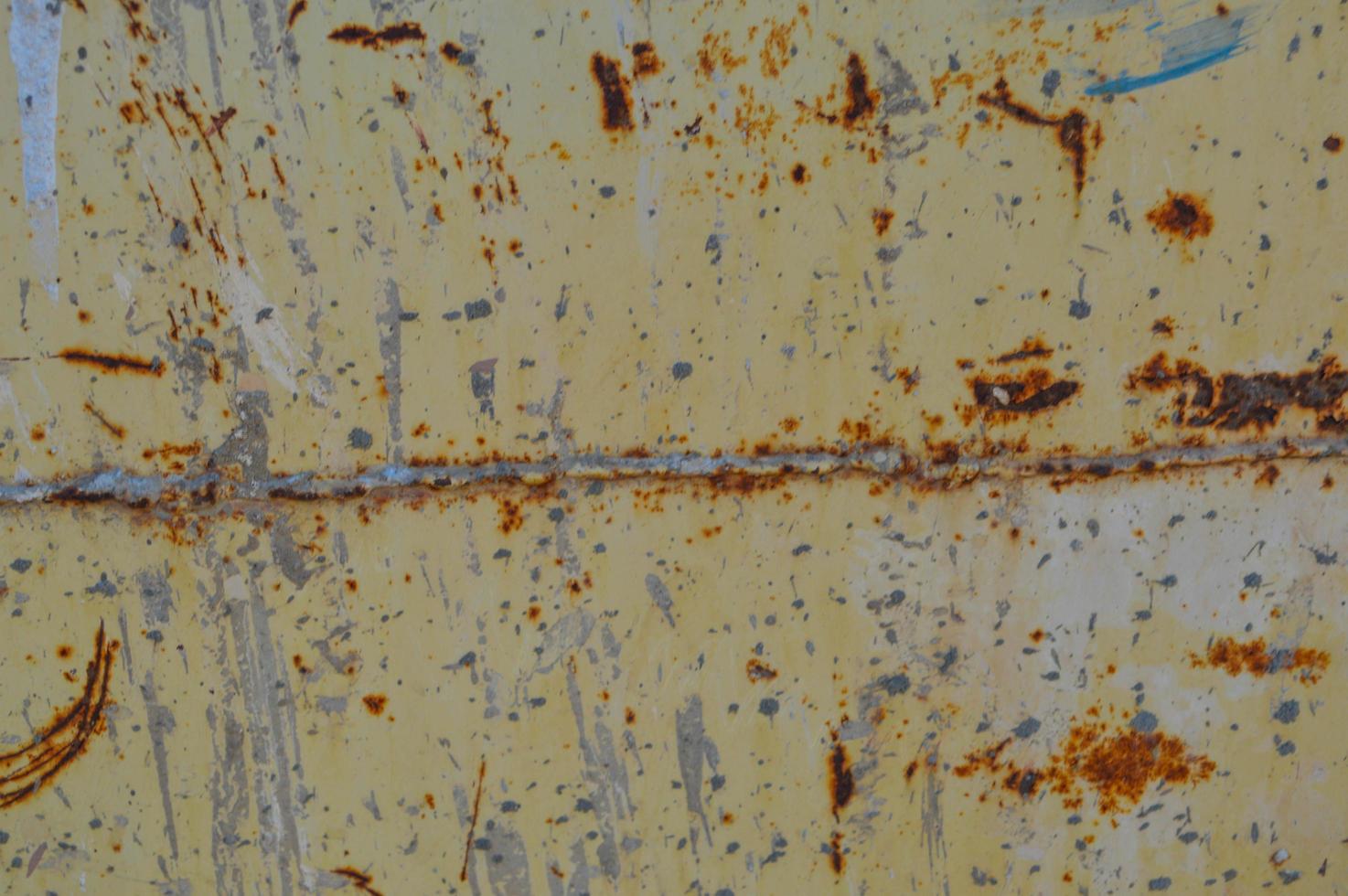 rusty, yellow with potholes texture. a piece of rusted metal with corrosion, paint destroyed by precipitation. a seam formed at the junction of the metals, which was covered with rust photo