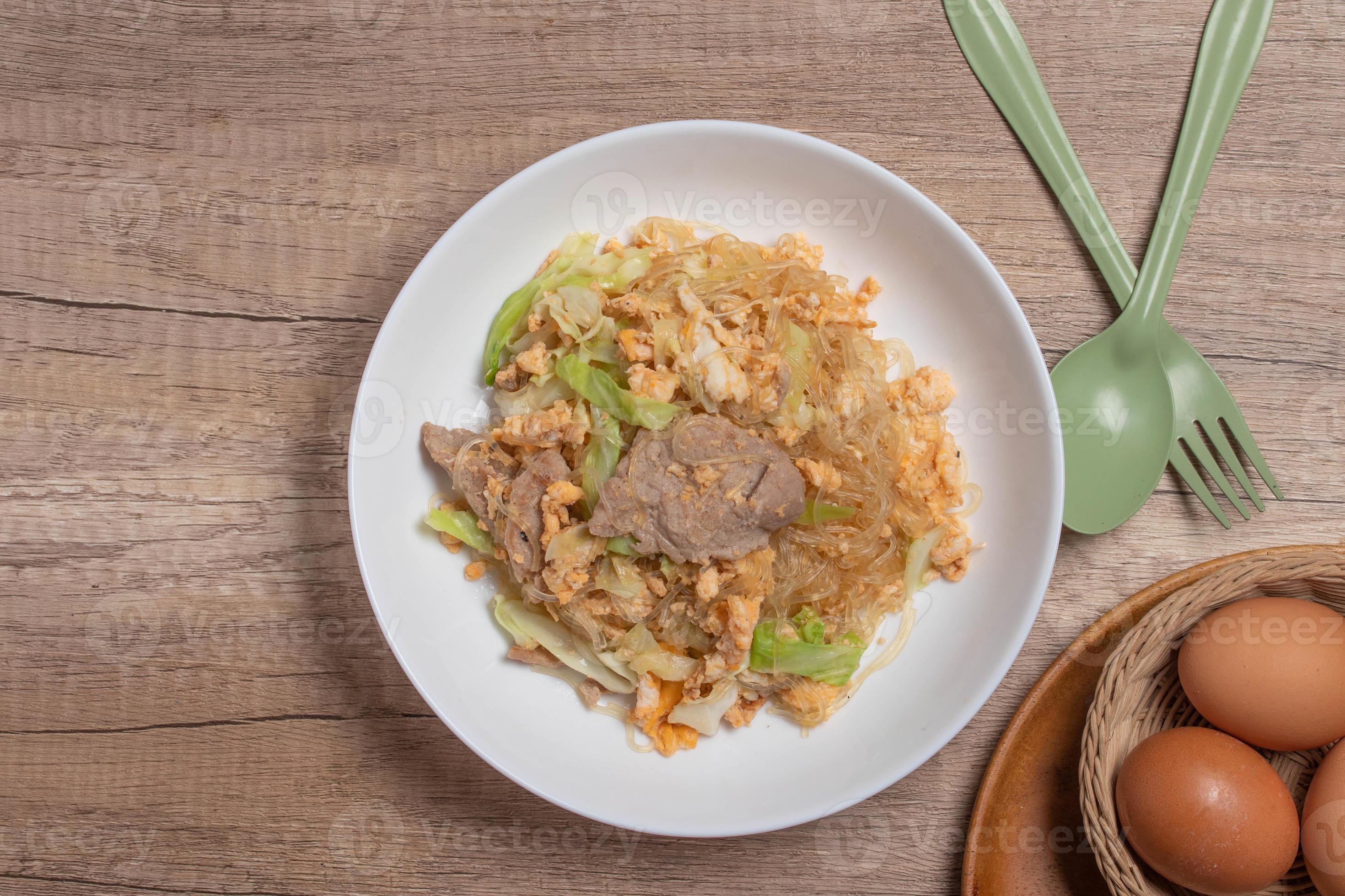 Stir fried vermicelli with pork, egg and collard greens in a white
